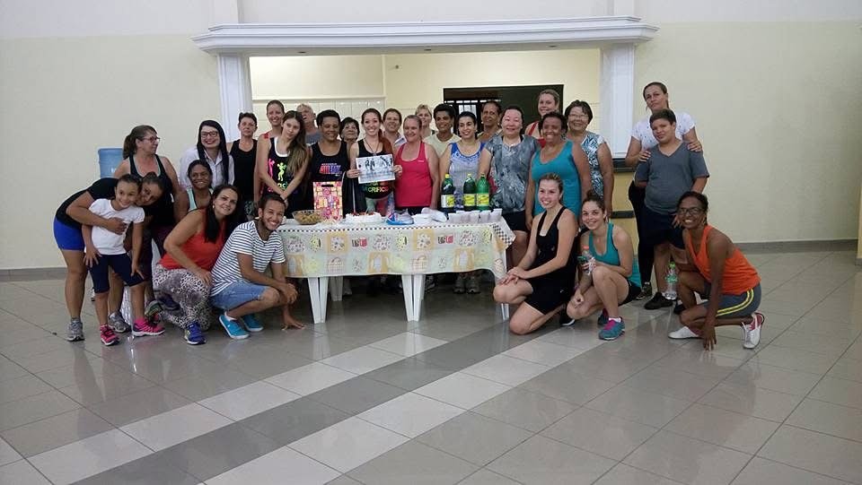 Alunas do EvoLua reunidas em confraternização, grupo posando em roda numa sala decorada